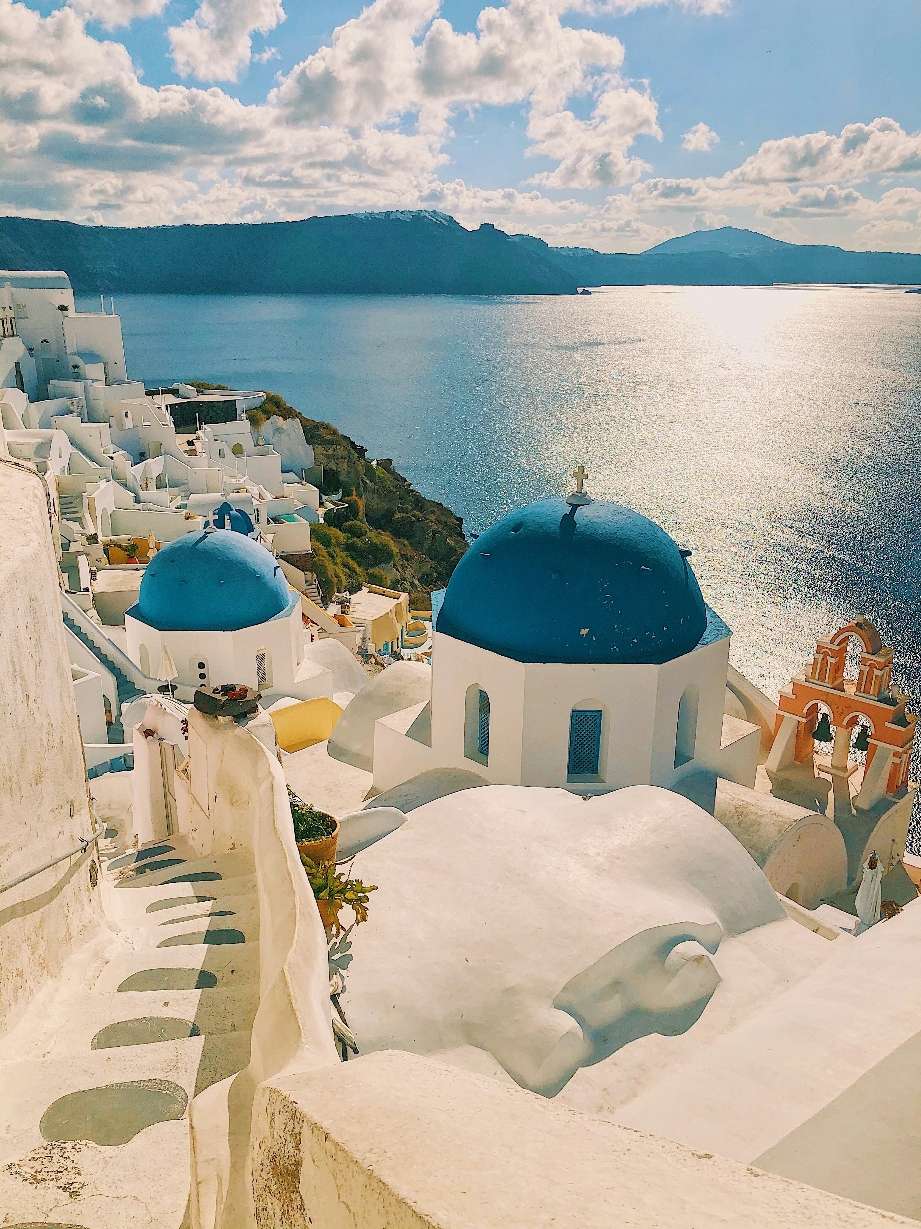 Santorini white buildings blue domes Greece - Premium Golden Visa real estate